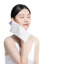 Woman holding a white facial wipe.