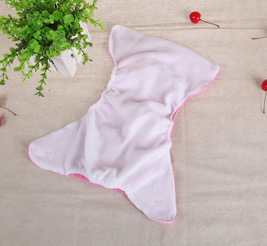Open white cloth diaper with pink trim.