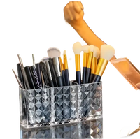 Three-compartment makeup brush holder in a trendy diamond chic bathroom with patterned mirror cabinet