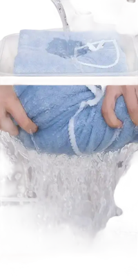 Blue baby bib being wrung out on trendy beach spa towel wrap for cool babes