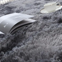 Gray shag rug with book and teacup showcasing trendy Vikama Tie-Dye Silk Wool rug