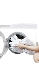 Mattress protector being loaded into a washing machine.