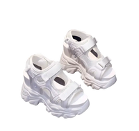 White platform sandals with velcro straps.