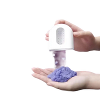 White dispenser sprinkling purple powder.
