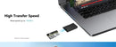 MicroSD card and reader next to a laptop.