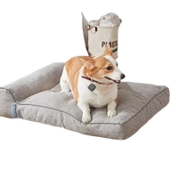 Gray pet bed with a bolster.