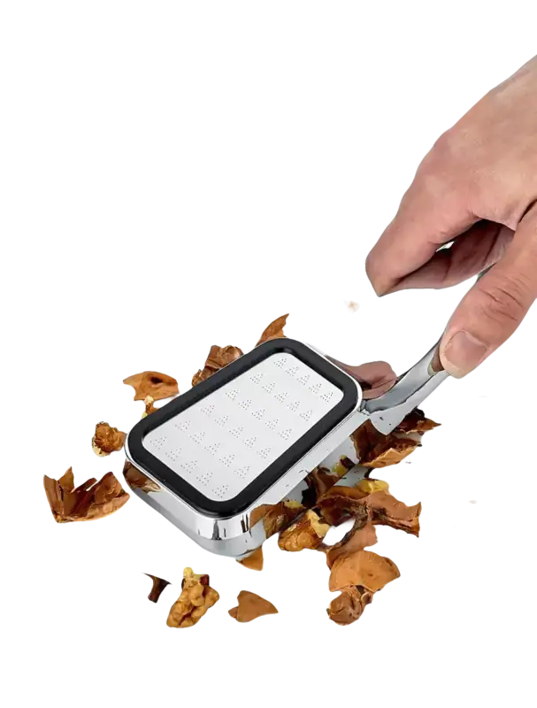 Chrome nutcracker with walnut shells.